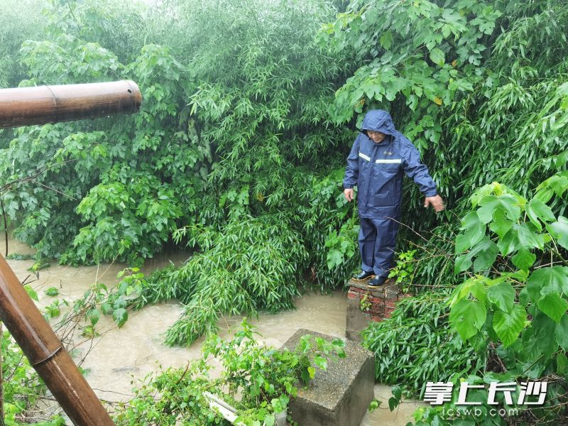 工作人員冒雨對各類排水設(shè)施進(jìn)行安全巡檢。