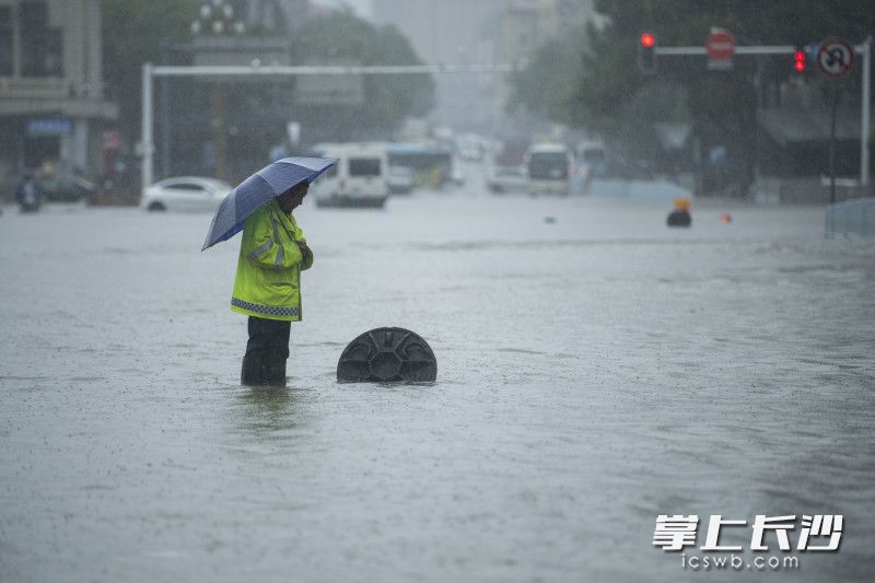 6月24日14時(shí)59分，芙蓉區(qū)車(chē)站中路,，市政工作人員守著一處排水井,，提醒著冒險(xiǎn)涉水通行的車(chē)輛和行人。