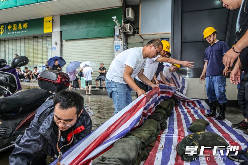 在長(zhǎng)沙火車站地鐵站的一個(gè)出入口,，工作人員正在進(jìn)行隔擋，防止積水灌進(jìn),。  均為長(zhǎng)沙地鐵供圖