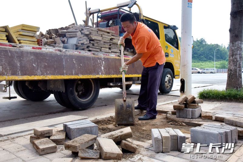 市政維護作業(yè)人員正在修補人行道磚塊。