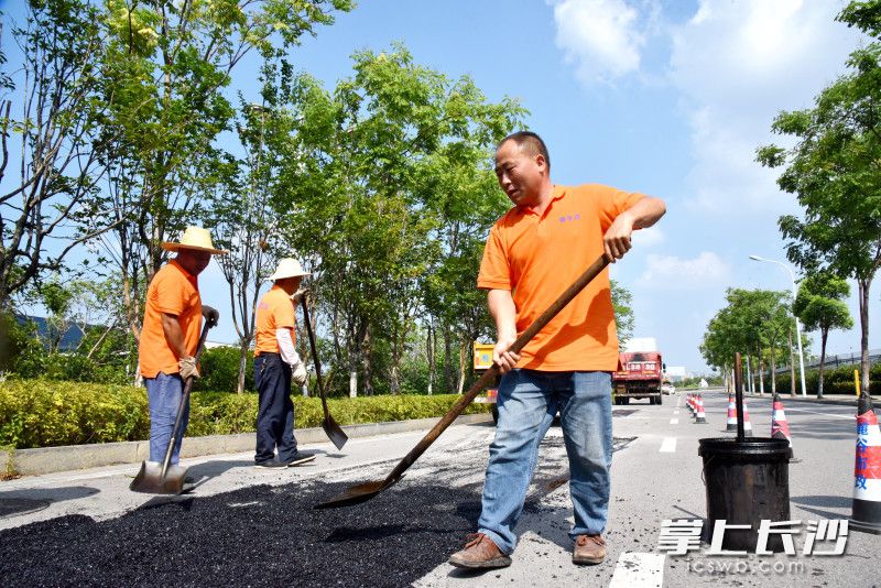 梁國華和同事們對破損路面進行維護,。  均為長沙晚報通訊員朱莉供圖