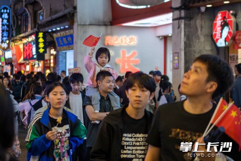 國慶期間,，不少游客隨身攜帶國旗出游,。