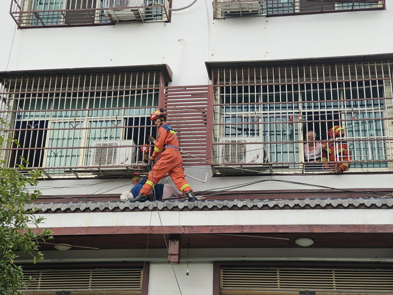 消防隊員在護窗外救援老人,。均為晚報通訊員供圖