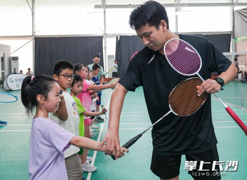 馬欄山運動公園羽小動羽毛球館里,，教練正在教學(xué)生們正確的握拍姿勢,。鄒麟 攝