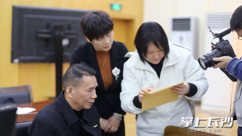 盲文老師給劉先生（左一）念判決書的內容,。 長沙晚報全媒體記者 李廣軍 攝