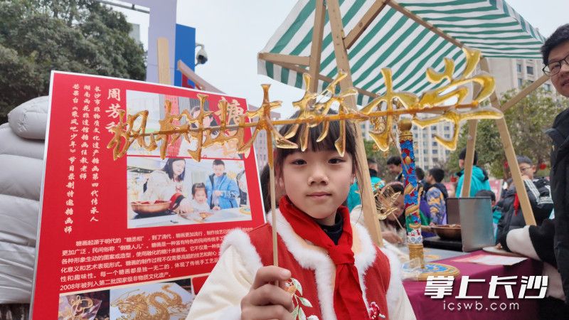 糖畫(huà)攤前，傳承人寫出的“楓樹(shù)山大橋小學(xué)”校名成了學(xué)生們的打卡熱門,。 長(zhǎng)沙晚報(bào)全媒體記者 岳霞 攝