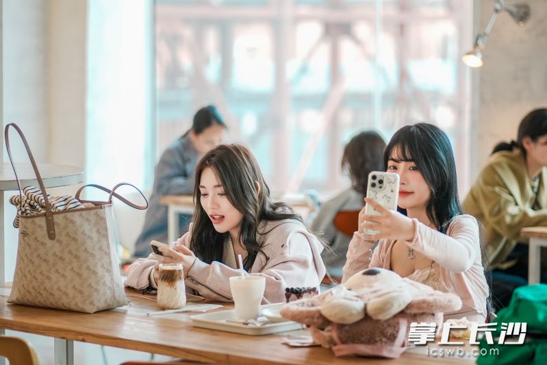 年輕人在“起風(fēng)”咖啡館打卡拍照,。