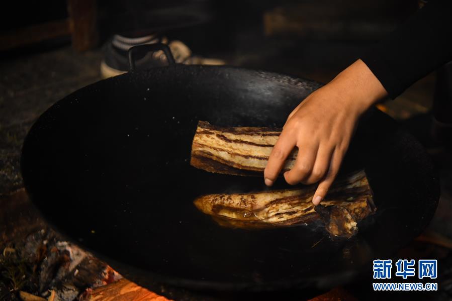 施林嬌在直播中煮臘肉，為炒臘肉做準備（4月23日攝）,。