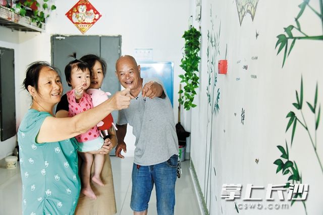 在愛晚花園小區(qū)改造后的樓梯間里，吳偉其（右一）一家其樂融融。黃榮佳 攝