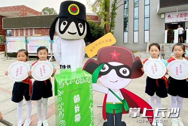 “雷鋒俠”帶著“節(jié)約箱”在雷鋒第二小學(xué)的門口迎接同學(xué)們的到來,。通訊員 供圖