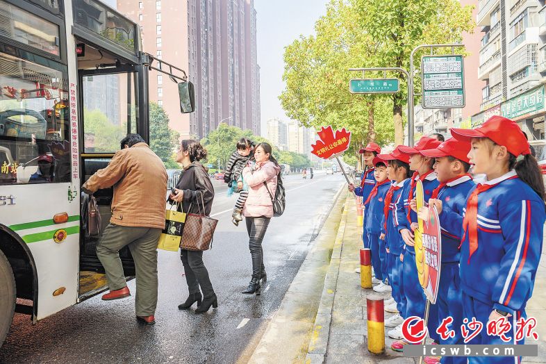 雨花區(qū)石壩路公交站臺(tái)邊,，來(lái)自雨花區(qū)楓樹(shù)山大橋小學(xué)的孩子們舉著排隊(duì)禮讓宣傳牌,，向等候公交的市民宣傳排隊(duì)禮讓?！￠L(zhǎng)沙晚報(bào)全媒體記者 陳飛 攝