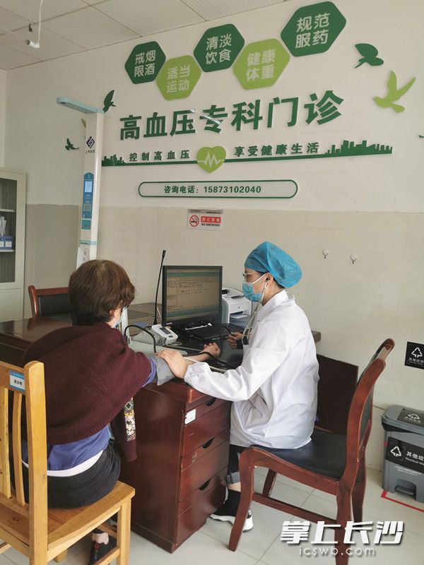 長(zhǎng)沙縣星沙醫(yī)院高血壓專科門診醫(yī)生為“慢性病自我管理小組”成員測(cè)量血壓,。