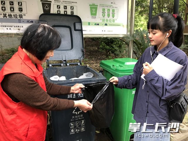 向陽(yáng)社區(qū)涉外花園小區(qū)志愿者桶邊指導(dǎo)居民將垃圾正確分類(lèi)。
