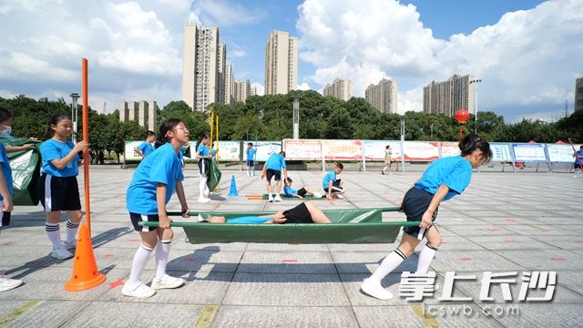 現場,，孩子們巧制擔架進行簡單的醫(yī)療“包扎”。