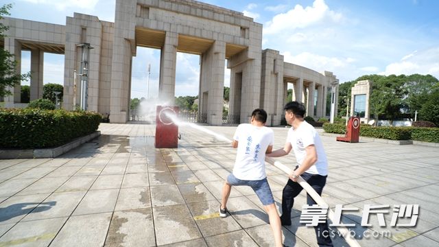 兩人齊心協力,，利用水壓搶，撲滅“大火”,。
