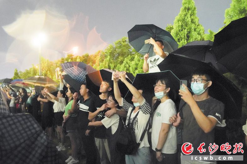 市民在雨中等待焰火晚會的到來,。
