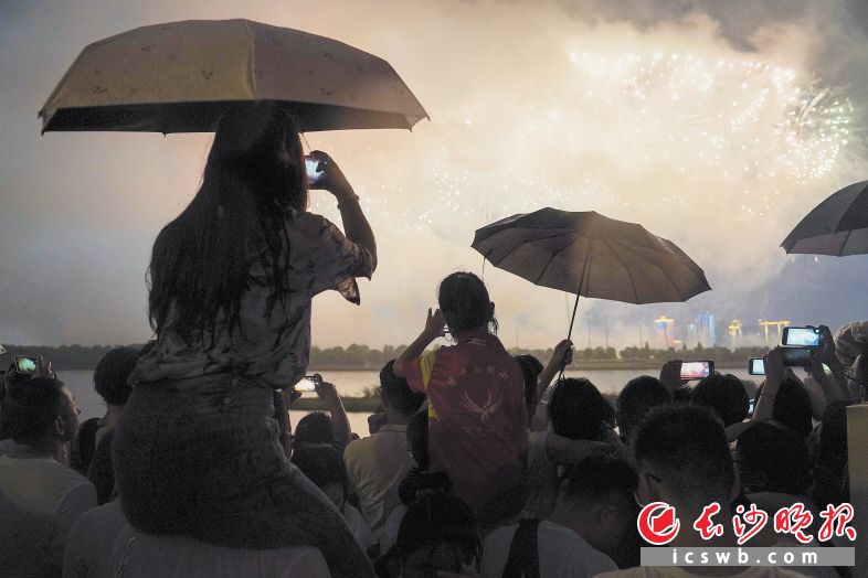 市民坐在同伴肩上,，力圖拍出最美的焰火“大片“。