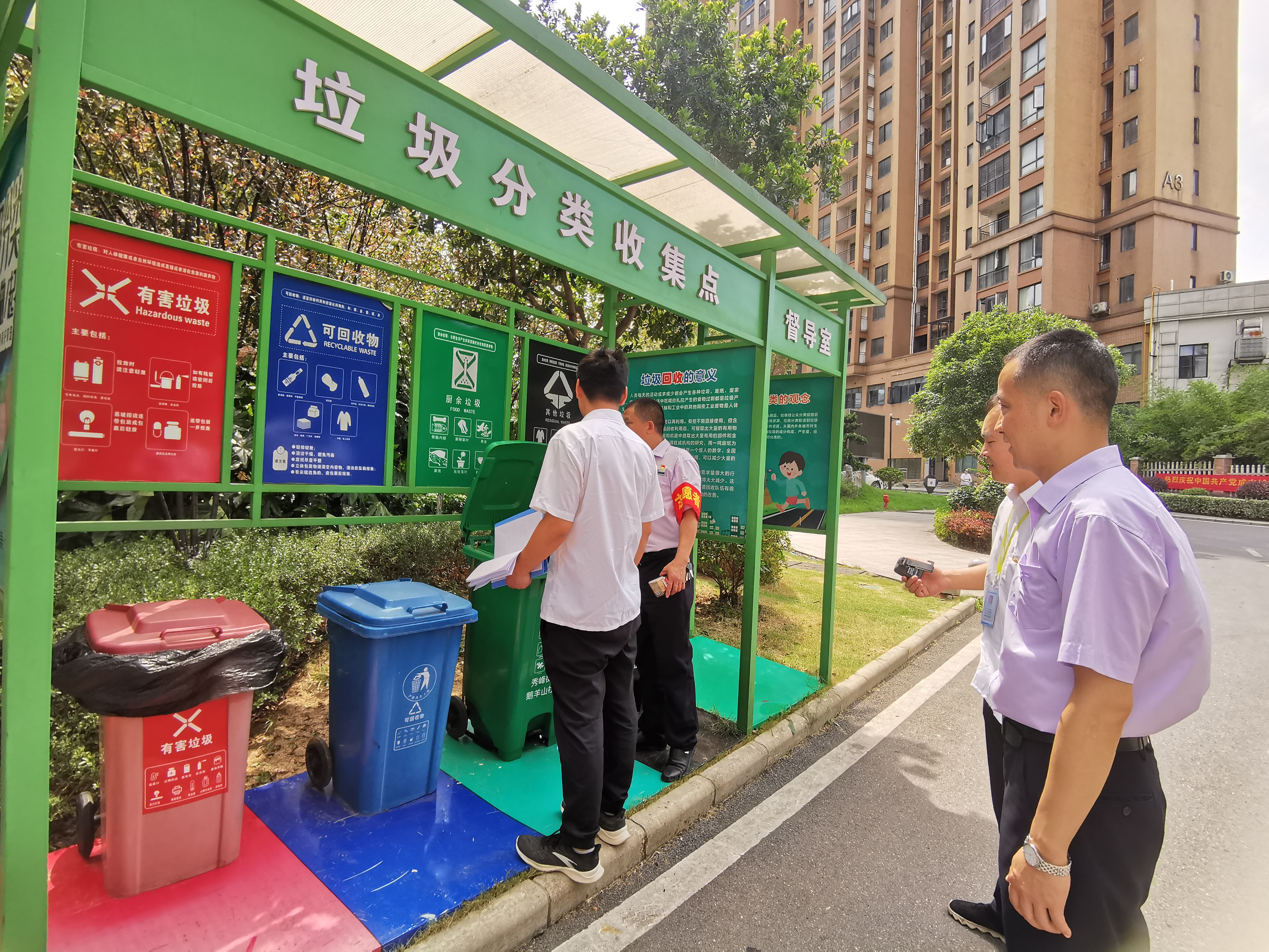 執(zhí)法人員正在垃圾分類收集點檢查垃圾分類情況。