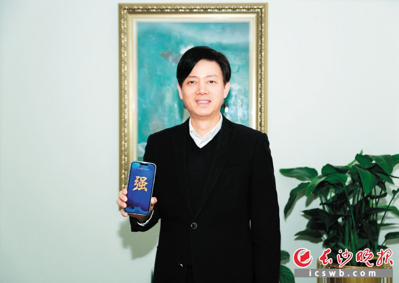 澳優(yōu)董事長顏衛(wèi)彬展示他推薦的“強(qiáng)”字,。　　長沙晚報通訊員 羅勝新 攝