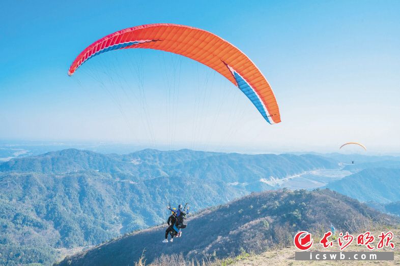 乘上滑翔傘,，游客們可以在空中欣賞鄉(xiāng)村田園美景，享受縱身一躍后飛翔的快樂(lè),。 長(zhǎng)沙晚報(bào)全媒體記者 鄧迪 攝