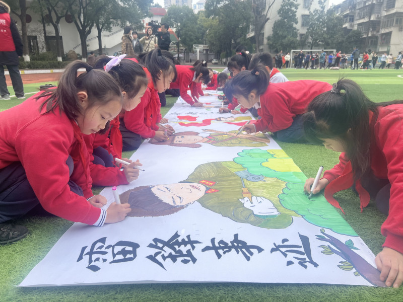 芙蓉區(qū)育才學校的操場上,，孩子們在10米長卷上繪下奉獻故事,，感受雷鋒精神的傳承。長沙晚報通訊員馮適攝