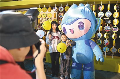 5月7日,，在浙江省杭州市湖濱步行街“3D笑臉墻”前,，攝影師為游客與杭州亞運會吉祥物之一“宸宸”拍攝合影。新華社記者 黃宗治 攝
