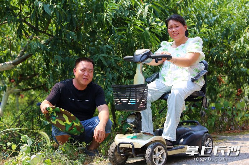 蔣千武將唐鈴抱上車,，去桃園摘桃。均為長沙晚報全媒體記者 賀文兵 攝